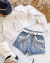Conjunto de short jeans com franja prata e camisa branca com franja na internet