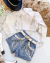 Conjunto de short jeans com franja prata e camisa branca com franja