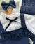 Conjunto de salopete marinho, camisa branca e laço de cabelo Talita