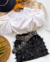 Conjunto de saia franja preta e blusa branca com renda.