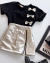 Conjunto de short saia zíper metalizado e blusa preta com laços pratas metalizados na internet