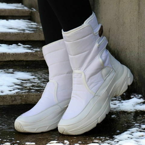Bota forrada branca para neve e frio, com design cano médio e sola branca, ideal para climas frios.
