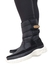 Bota forrada preta de cano médio, com detalhe em couro e sola branca, projetada para oferecer conforto e aquecimento em climas frios e nevados.