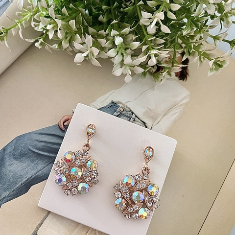 Brinco banhado com design floral e pedras brilhantes.