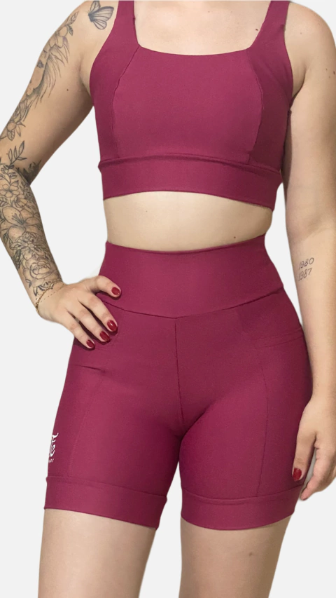 Conjunto de top e shorts na cor vermelha Marília, modelo fitness, com detalhes de costur  e design moderno.