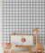 Papel de parede minimalista quadriculado azul com fundo branco em quarto infantil decorado com móveis de madeira
