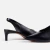Sapato slingback preto com salto baixo, ideal para compor looks elegantes e confortáveis. Tendência na moda feminina.