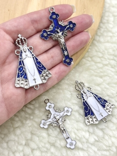 Kits de entremeio com peças de Nossa Senhora Aparecida e crucifixo em níquel, com detalhes em azul e branco.