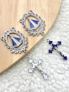 Conjunto de dois entremeios em formato oval com a imagem de Nossa Senhora Aparecida e dois crucifixos, um azul e um branco, 