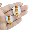 Entremeio de acrílico branco com imagem da Nossa Senhora de Fátima, segurando um coração.