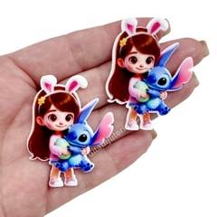 Aplique de acrílico com uma menina morena e Stitch segurando um ovo de Páscoa, medindo 4,5 cm.