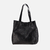 Tote bag negra de cuero, estilo Mérida, con asas largas y diseño amplio.