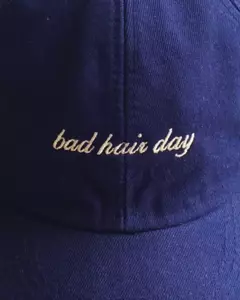Boné azul com bordado "bad hair day" na parte frontal. Boné de algodão bordado azul marinho bad hair day ajustável.
