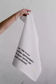 Pano de prato branco com texto em preto, segurado por uma mão. Pano de prato de algodão estampado humor divertido coleção basics frases sinceras oportunidades.