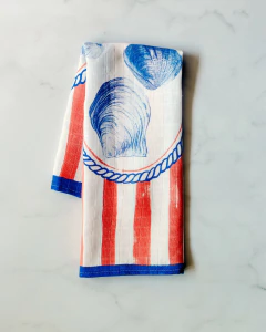 Pano de prato com estampa de conchas em fundo listrado vermelho e branco. Pano de prato algodão Isabela Leão Matheus Fernandes criativo conchas.