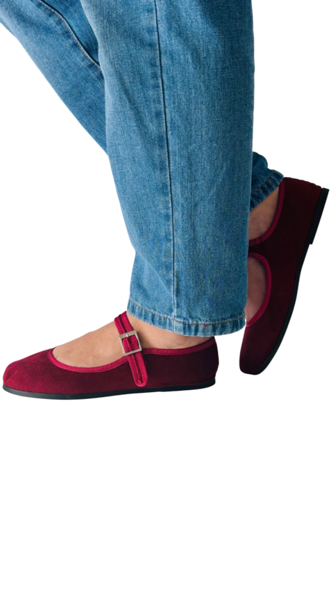 Zapatos tipo ballerina color burdeos con hebilla, combinados con jeans claros.