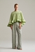 Calça feminina de alfaiataria verde combinada com blusa ampla em babados e mangas soltas, vista frontal
