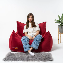 Una joven sentada en un fiaca modelo DUBAI grande y rojo, este sillón ofrece comodidad y estilo.