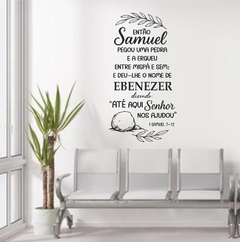 Adesivo de parede com frase bíblica de 1 Samuel 7:12 decorando sala de espera com banco e planta.
