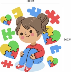 Adesivo de parede com ilustração de uma criança sorridente rodeada por peças de quebra-cabeça coloridas e corações, simbolizando inclusão e autismo.