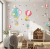 Adesivo de parede infantil com balões coloridos, elefante e raposa em um quarto decorado para crianças