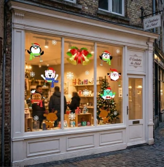Vitrine decorada para Natal com adesivos natalinos coloridos, incluindo pinguins, ursos, rena, biscoito de gengibre, Papai Noel, sinos dourados com laço vermelho e flocos de neve brancos