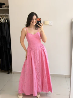 Mulher sorrindo usando vestido longo rosa de laise com alças finas, tirando selfie em frente ao espelho em ambiente interno
